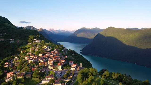 Dramatic aerial drone footage of the Monte Bre village by lake Lugano in the alps in Switzerland in Canton Ticino. Shot with a rotation motion
