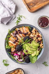 Grilled chicken breast, fillet and fresh vegetable salad of lettuce, arugula, spinach, avocado, onion and walnut with blackberry dressing. Healthy lunch menu. Diet food. Top view
