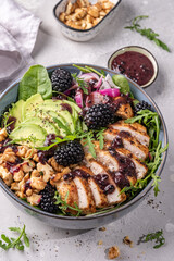 Grilled chicken breast, fillet and fresh vegetable salad of lettuce, arugula, spinach, avocado, onion and walnut with blackberry dressing. Healthy lunch menu. Diet food. Top view