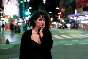 Young woman touching her face standing on the street at night
