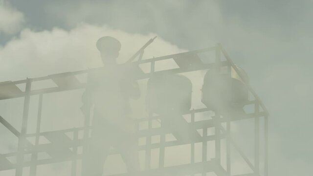 Security , guard , policeman stay in watch tower and looking around with not licensed decorative uniform and weapon . Silhouette of guard tower or prison tower with security man . Slow Motion . 