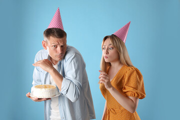 Greedy man hiding birthday cake from woman on turquoise background - obrazy, fototapety, plakaty