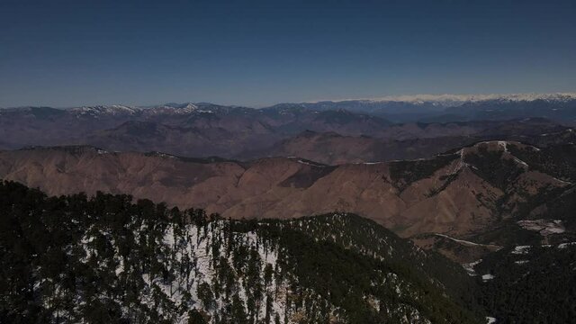 snow mountains covered with vegetation trees. aerial drone shot of Himalayan mountain range landscape