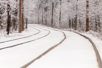 An old tram moving through a winter forest