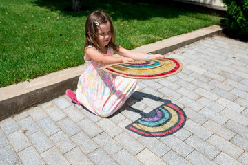 Cute child girl playing with rainbow sun catcher outside. Fun crafting ideas for kids from...