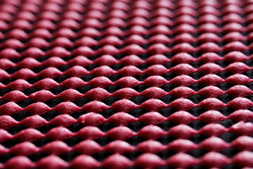 Many red miniature rubber pads on a black. Technological concept of visual perspective and mass production technologies. Modern backdrop and background. Selective focusing