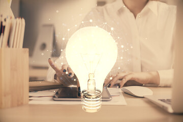 Double exposure of light bulb hologram and woman holding and using a mobile device. Idea concept.