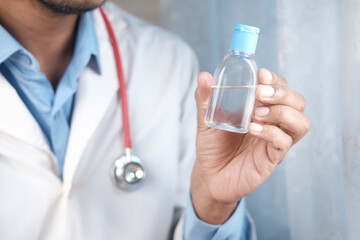 doctor holding hand sanitizer close up 
