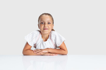 Beautiful Caucasian preschool girl looking at camera isolated over white studio background. Copyspace. Childhood, education, emotions concept