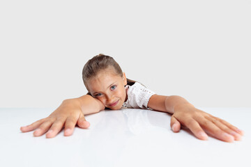 One Caucasian school girl, pupil isolated over white studio background. Copyspace. Childhood, education, emotions concept. Looks tired