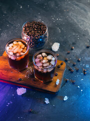 Two cold cold brew coffees on a black table, neon lighting. Refreshing summer iced coffee