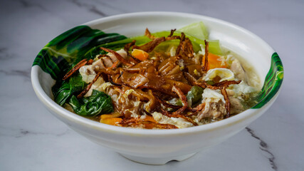 Flat Noodles cooked in Egg Gravy (Wan Tan Hor). Isolated in bowl.