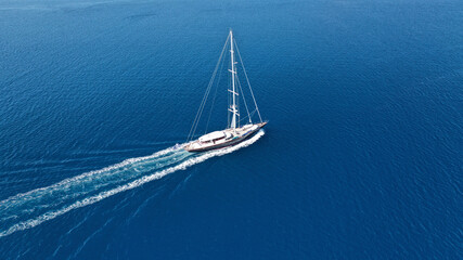 Aerial drone photo of beautiful sailboat cruising deep blue open ocean Aegean sea