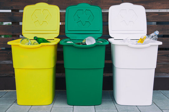 Three full dustbins for sorting trash on the backyard