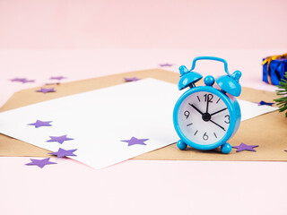 Blue alarm clock on a pink background.
