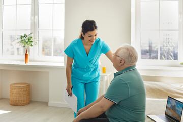 Woman doctor nurse asking for old patient well-being sitting on bed at hospital ward. Caregiver and...
