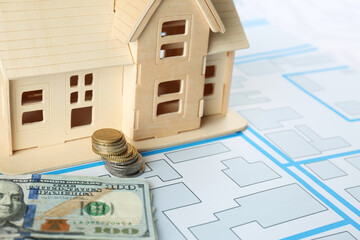 Money and house model on cadastral map, closeup