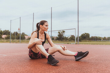 Woman sits on a playground and relaxes during sports training