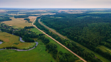 Fototapeta premium Aerial landscape of winding river in green field, top view of beautiful nature background from drone, seasonal summer landscape with copy space.