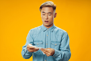 a man of asian appearance in a shirt with a handkerchief in his hands