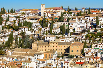 Old houses on a hillside with their roofs and trees. Albaicin Granada.