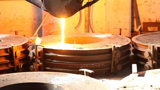 Trabalho &aacute;rduo em uma fundi&ccedil;&atilde;o. Forno de fus&atilde;o de metal em usina sider&uacute;rgica. Vazamento de metal fundido, metalurgia, fundi&ccedil;&atilde;o de a&ccedil;o. Fabrica&ccedil;&atilde;o de a&ccedil;o