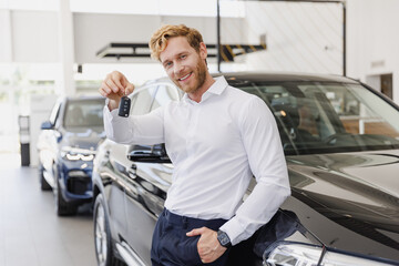 Naklejka na ściany i meble Man smiling happy male customer buyer client wearing white shirt giving keys fib chooses auto want buy new automobile in car showroom vehicle salon dealership store motor show indoor. Sales concept