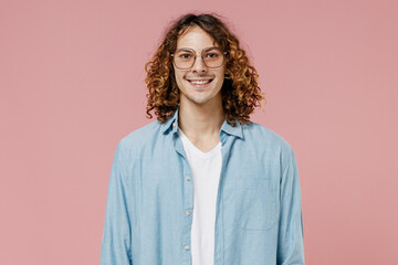 Fototapeta premium Young smiling happy fun man 20s with long curly hair wear blue shirt white t-shirt glasses look camera isolated on pastel plain pink color wall background studio portrait. People lifestyle concept