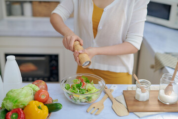 Closeup mid section of a chef putting salt and Pepper in the kitchen