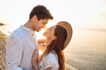 Close up profile young happy couple two friends family man woman in white clothes hug touch noses going to kiss together at sunrise over sea beach ocean outdoor seaside in summer day sunset evening