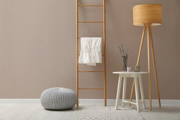 Stylish room interior with pouf, ladder and decor elements. Space for text © New Africa