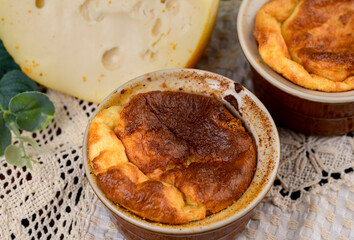 French baked cheese souffle in rameken on wood table