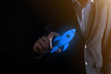Start up concept with businessman holding abstract digital rocket icon rocket is launching and soar...