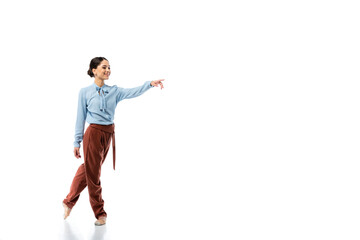 Brunette ballerina pointing with finger on white background