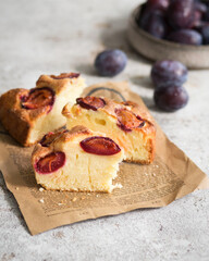 A traditional American plum pie from the New York Times newspaper. Sweet cupcake with fruit on a light background and a newspaper. Autumn baking. A piece of cake with cream