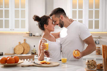 Lovely couple enjoying time together during breakfast at table in kitchen