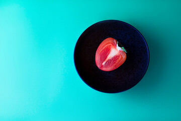 Persimmon on a black plate. Green background. Abstract background.