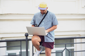 male freelancer  doing work using the laptop in the street