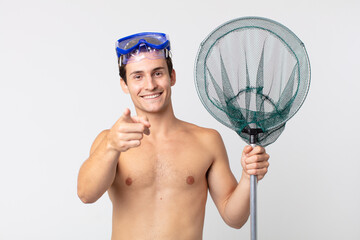 young handsome man pointing at camera choosing you with goggles and a fishing net - Powered by Adobe