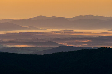 Morning mists illuminated by the rays of the rising sun seen from the summit of Połonina Wetlińska, the Bieszczady Mountains, the Carpathians