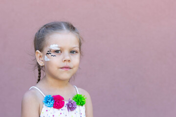 Portrait of caucasian girl of five years old looking at camera on the purple background