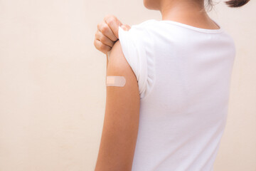 Woman white shirt showing her arm after receiving vaccine shot on White background.
