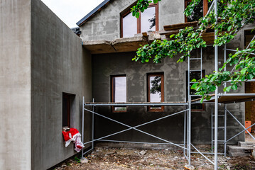 Applying fresh construction glue layer on insulated wall for covering fiberglass reinforcing mesh...