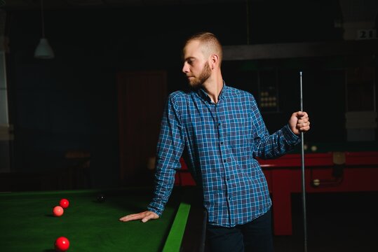 Young Handsome Man Leaning Over The Table While Playing Snooker