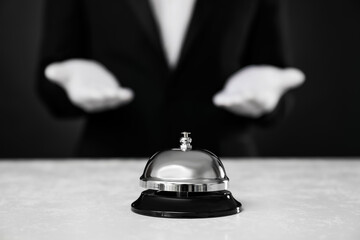Butler at white desk with service bell, closeup view