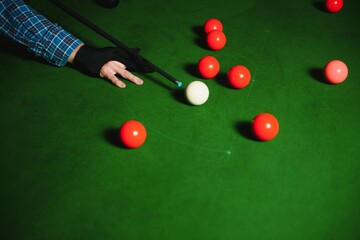 Thoughtful man plays billiards. Billiard room on the background.