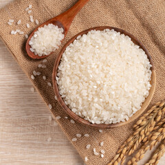 White rice in a bowl on wooden table background.