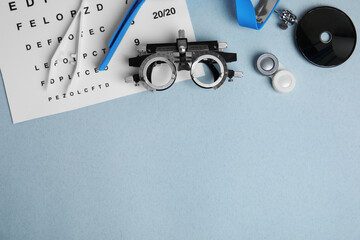 Different ophthalmologist tools on grey background, flat lay. Space for text