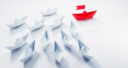 Group of paper boats with red leader on white background