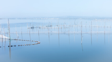 Imagen marina en azul de la albufera de valencia con redes. Tranquilidad. Paz. Honirico.